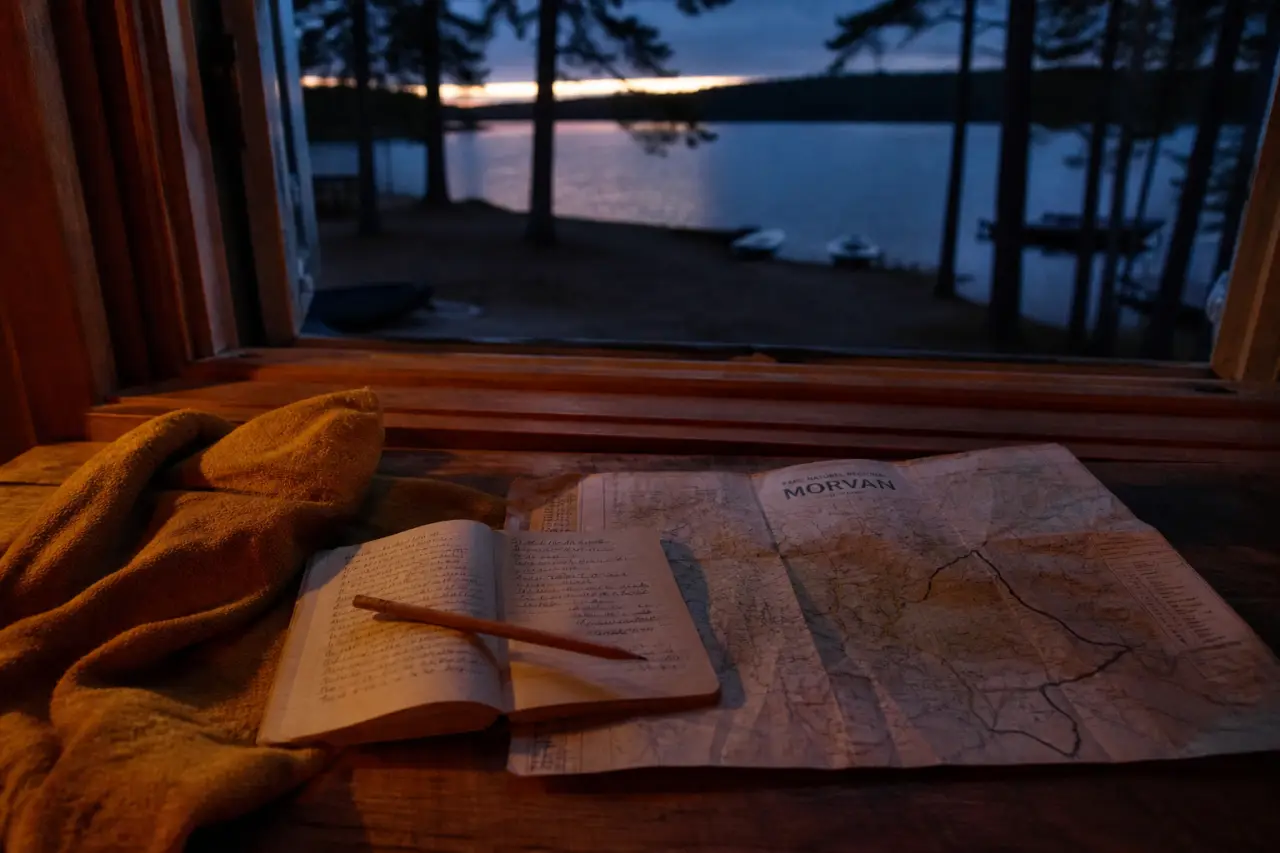 Séjour dans le Morvan : carnet et carte près d’un lac au crépuscule